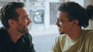 Smiling transgender couple kissing sitting cafeteria at weekend leisure close up