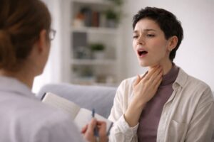Personne travaillant sa voix avec un orthophoniste pour passer d’un registre vocal à un autre sans effort